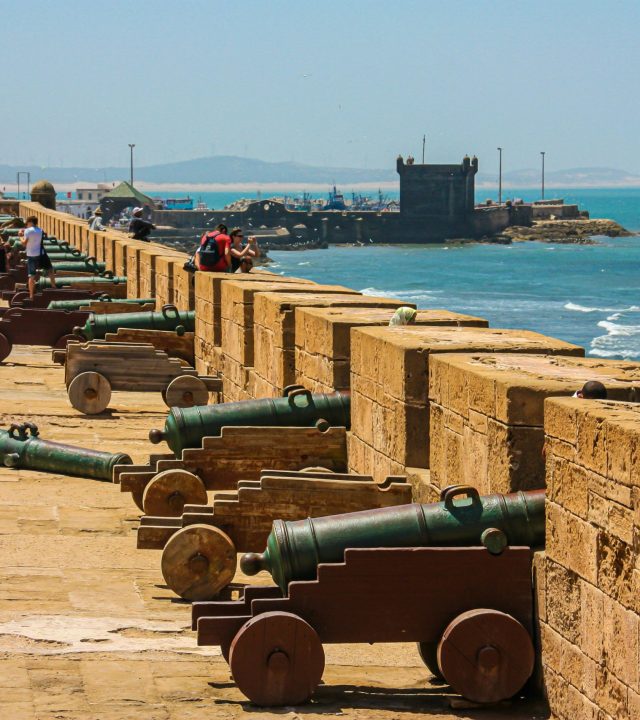 Cannons on a fortress wall facing the sea, capturing historical and coastal scenery.