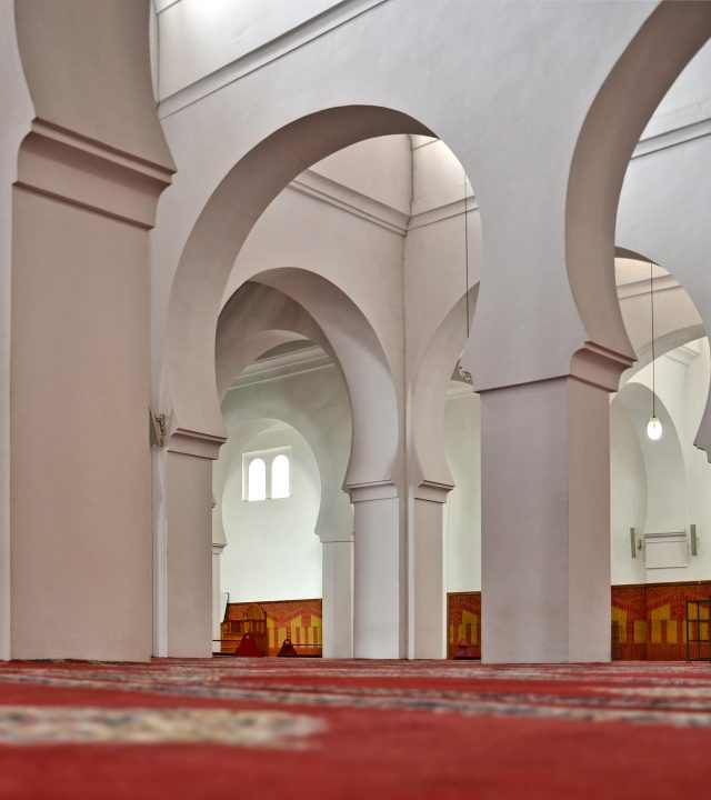 Low-angle view of Al-Qarawiyyin Mosque's arches in Fès, showcasing Islamic architecture.