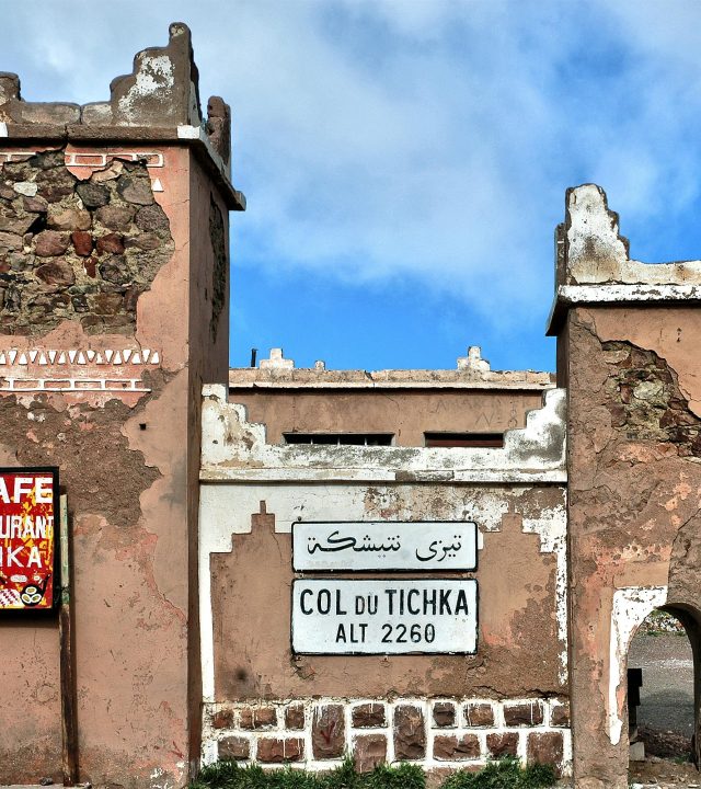 Historic Col du Tichka sign and structure on a sunny day in Morocco.