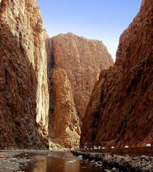 Captivating view of Todra Gorge's towering cliffs and tranquil stream in Tinghir, Morocco.