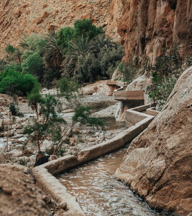 Traditional irrigation channel in rocky Tinghir landscape, capturing serene nature in Morocco.