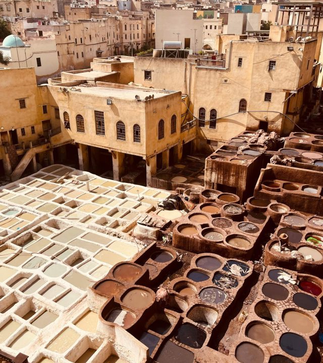 Aerial photo of vibrant traditional tannery in Fez, Morocco, showcasing ancient leather dyeing process.