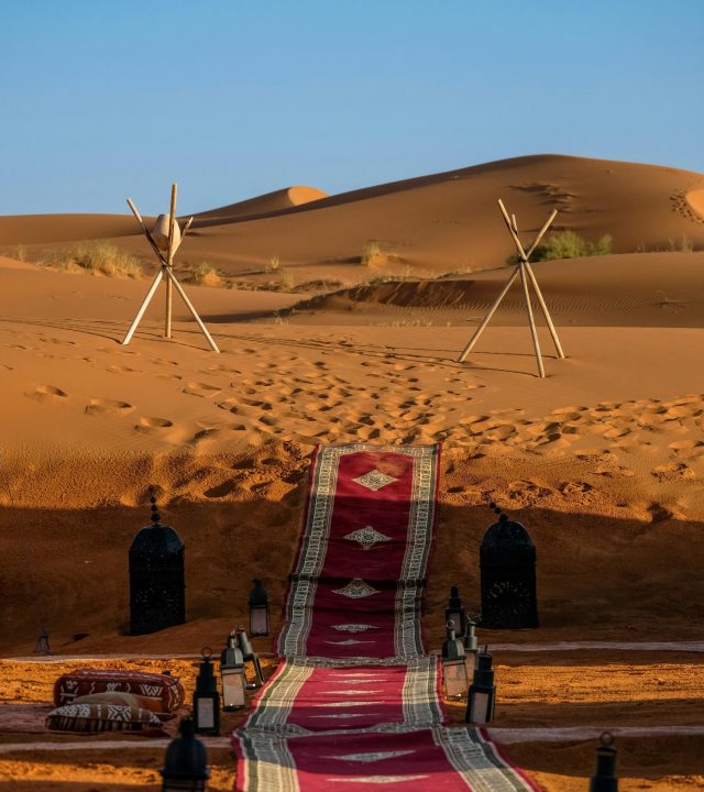 Explore the stunning sunset in Merzouga, Morocco with a vibrant pathway through the dunes.